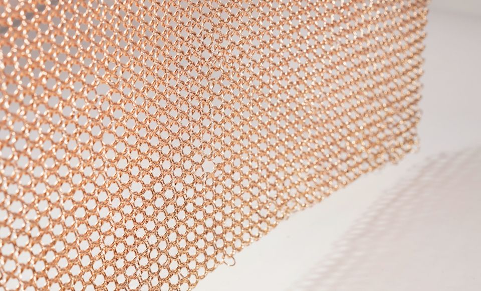 A piece of unfolded rose gold chainmail curtain