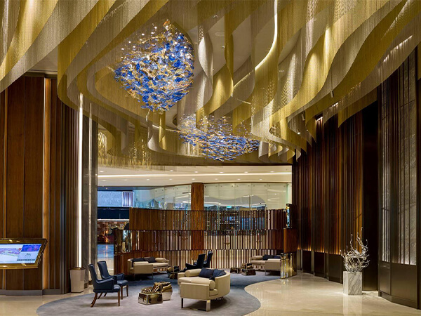Área de recepción del lobby del MGM Lion Hotel con cortinas de cuentas de metal instaladas en el techo.