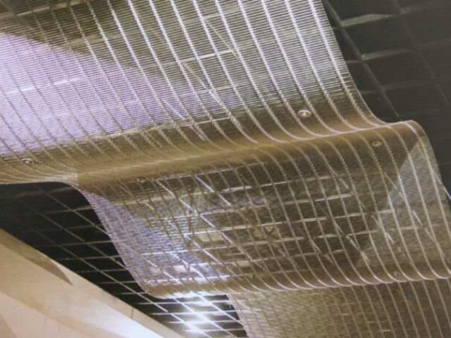 Woven wire drapery is used for ceiling design.